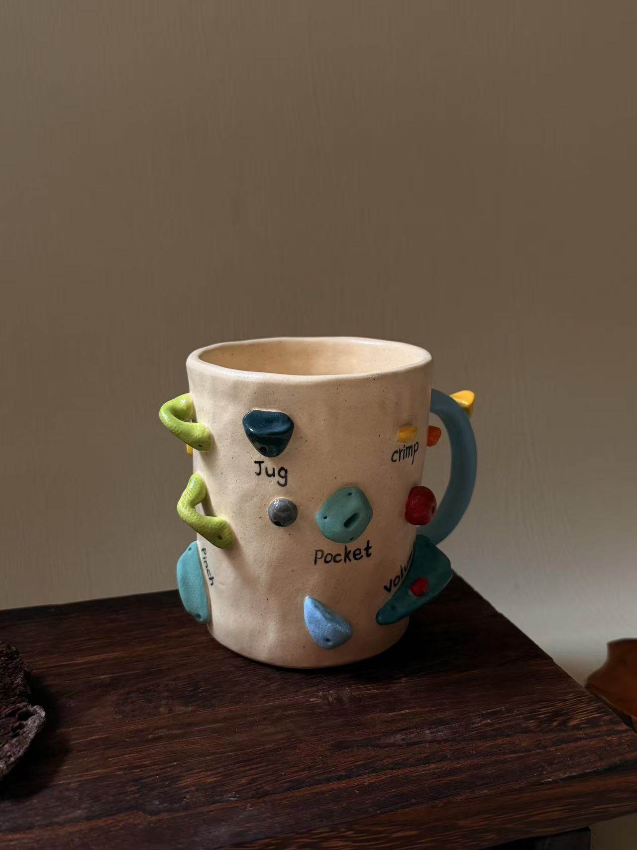 Handmade ceramic mug with rock climbing design, suitable for coffee, milk, and both hot and cold drinks.